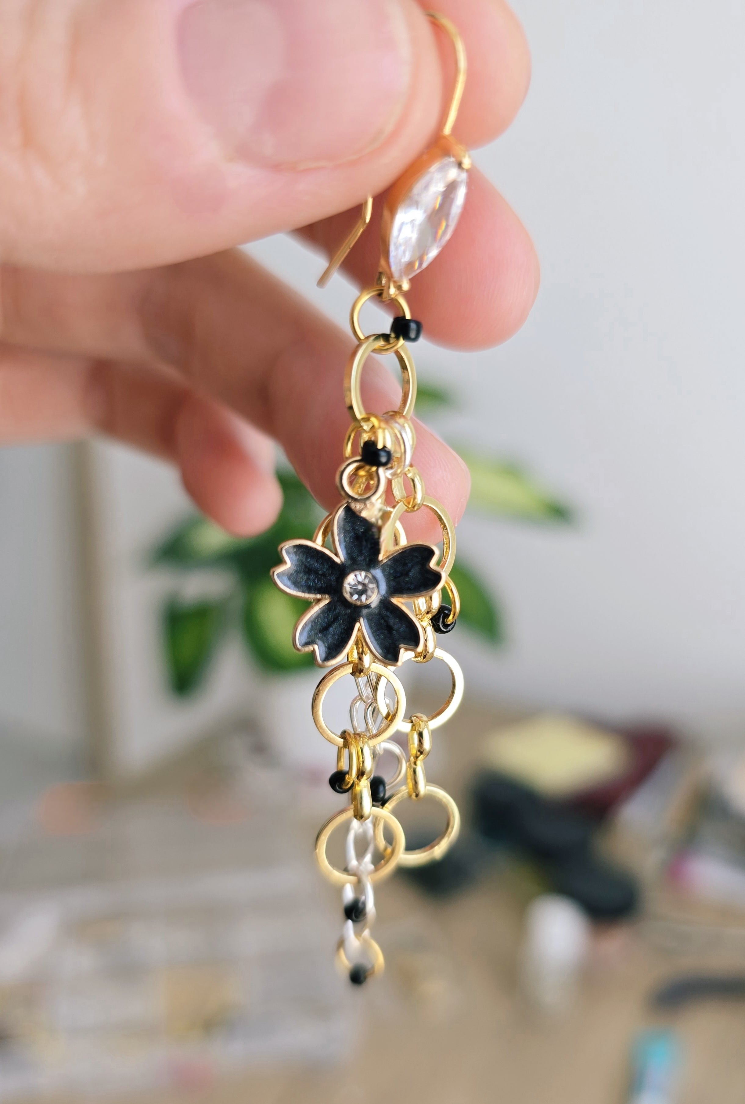 Dreamy chain earrings with black flower charm. Gold plated hooks