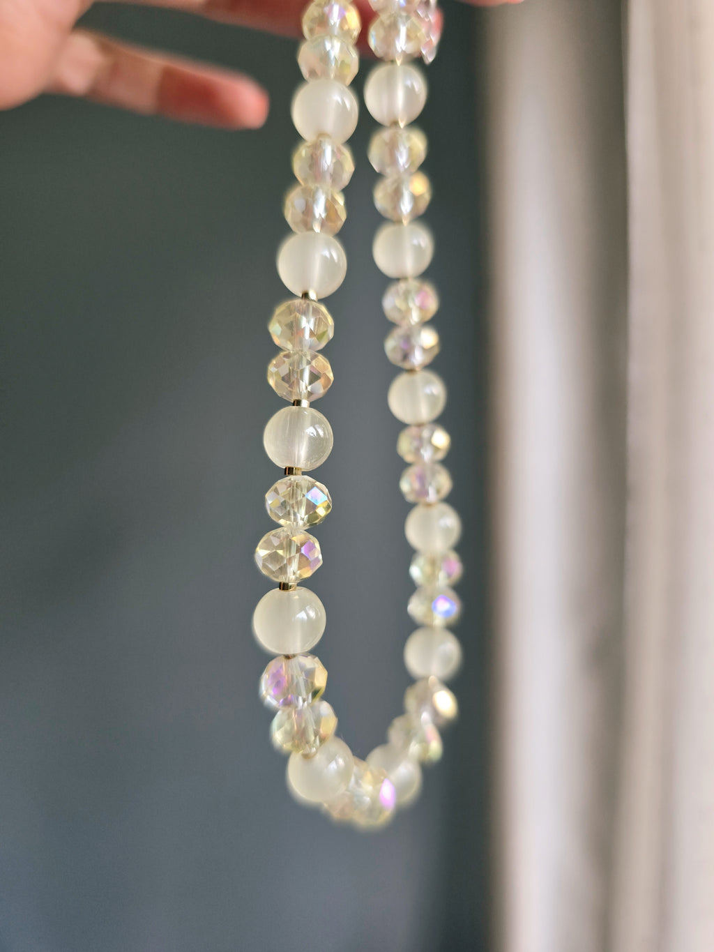 shiny butter yellow beaded necklace on gray wall background