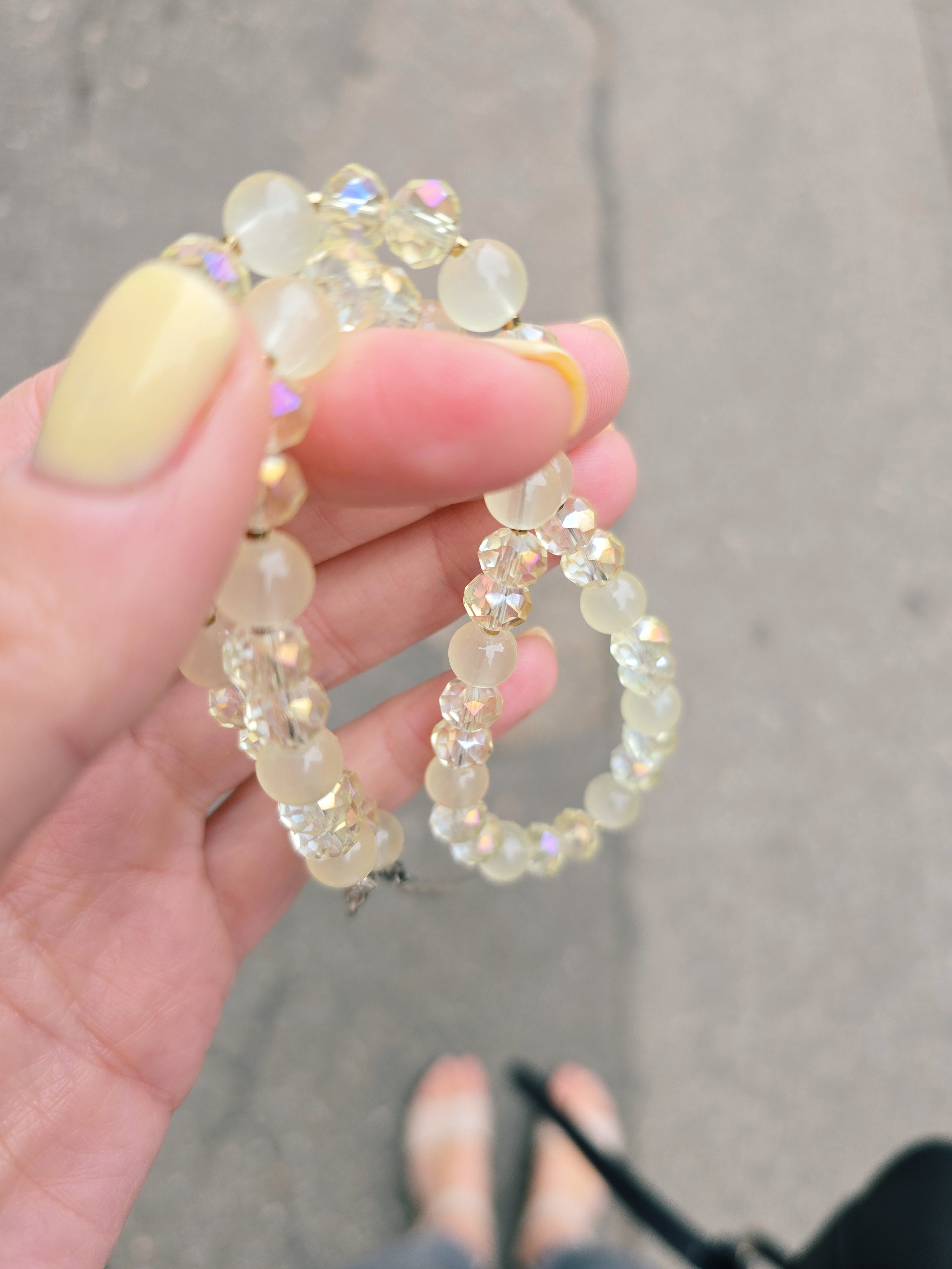 Hand holding a beaded bracelet with a blurred background